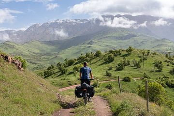 Un cycliste solitaire sur une petite route de montagne sur Jeroen Kleiberg