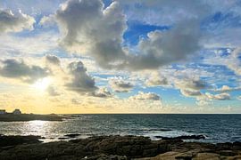 A coastal scene with houses in the distance, silhouetted against the light by Theodor Decker