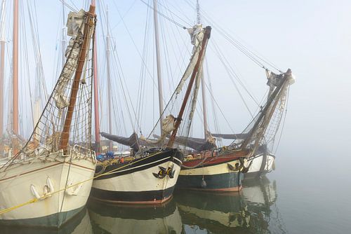 Oude zeilschepen aan de kade in Kampen in de mist