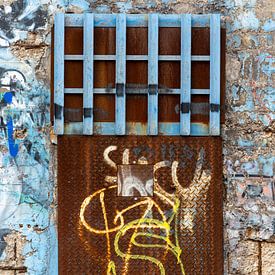Roestig stalen loodsdeur met graffiti van Wil Wijnen